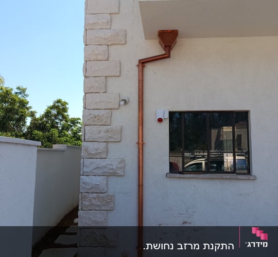 צינור נחושת על קיר חיצוני של בניין
